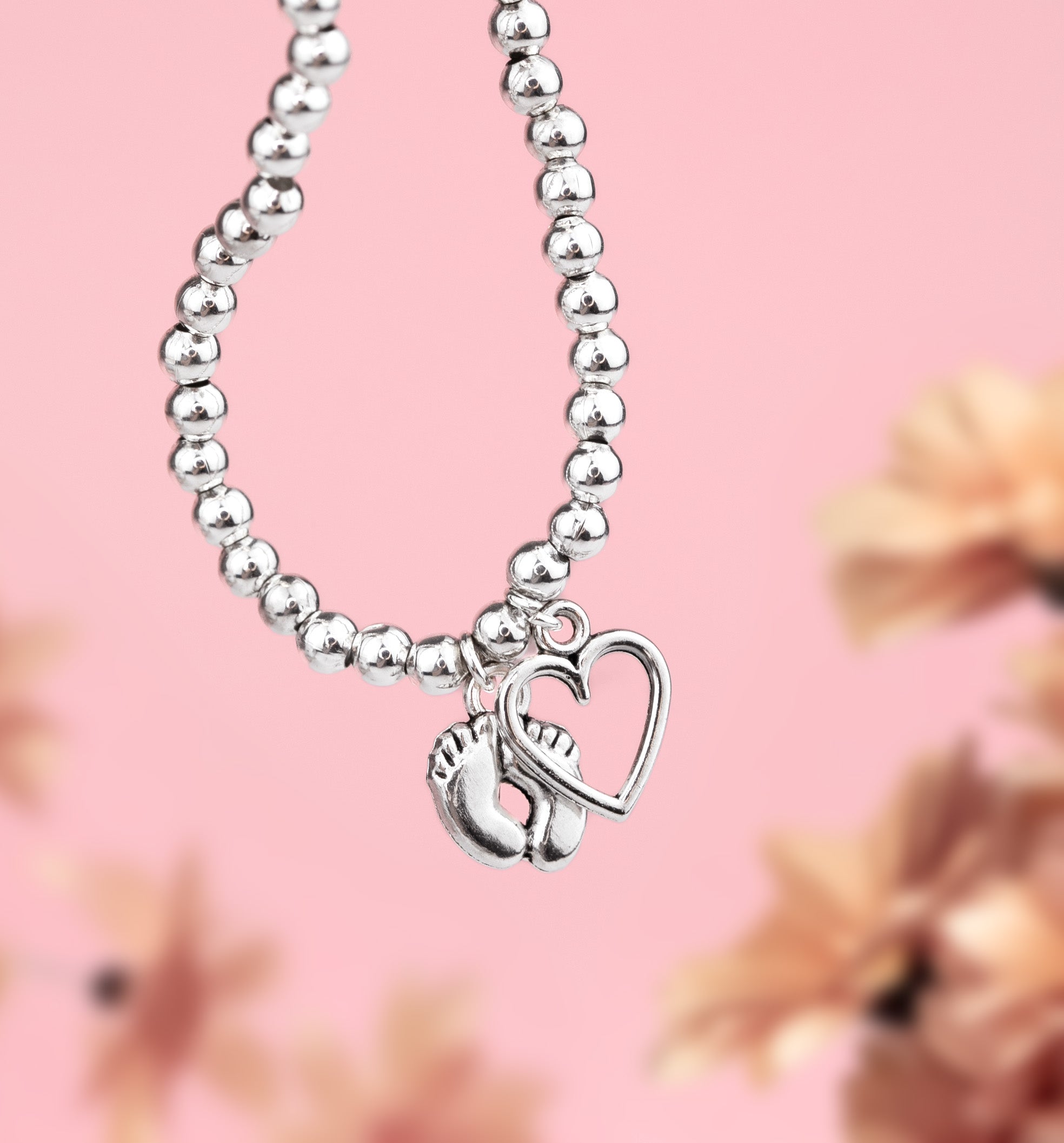 Mum to be bracelet, silver-plated with a cute baby feet charm and a heart. Gift guide for baby showers and for a Mum to Be