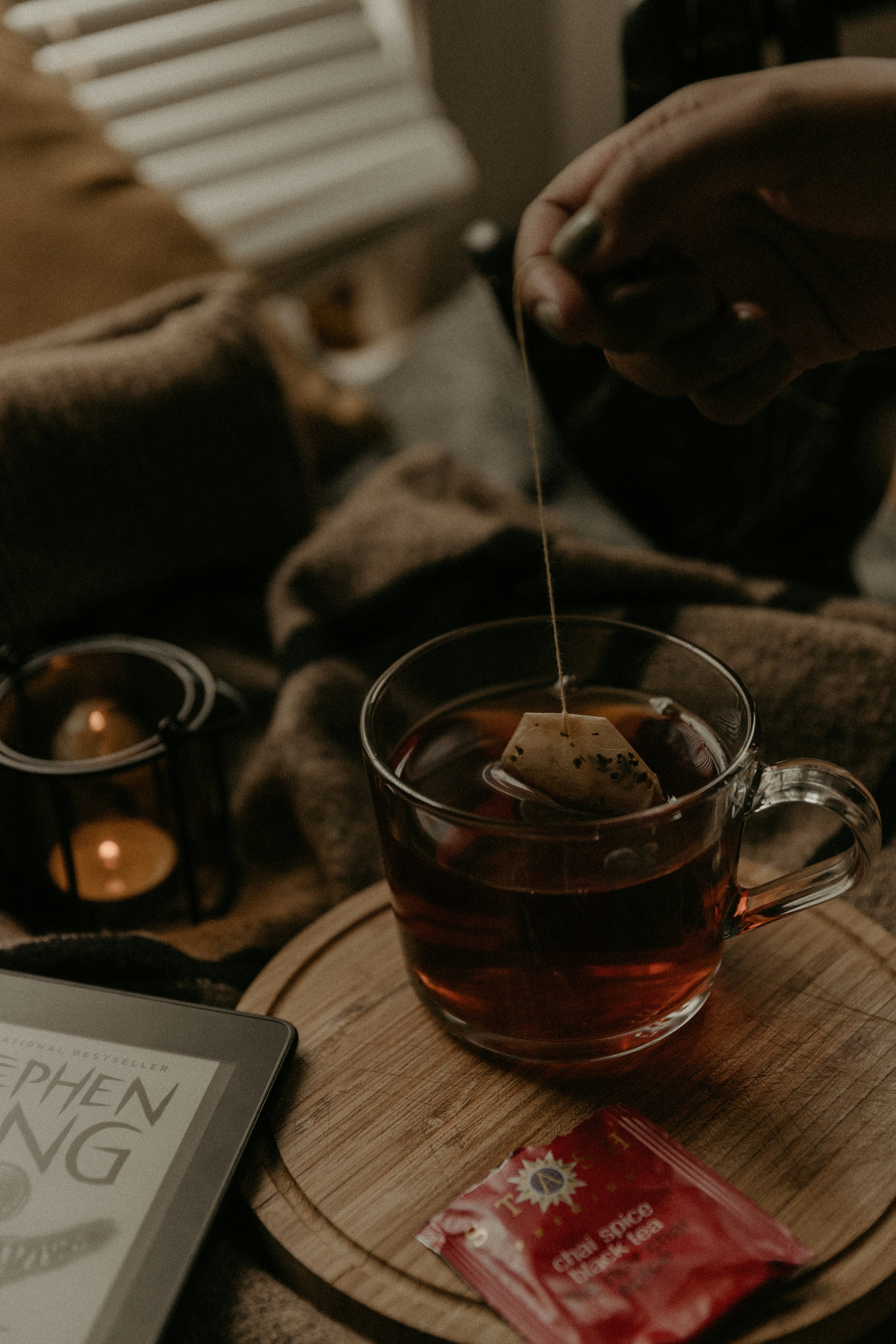 a cosy autumn scene with a woman hand making a cup of tea