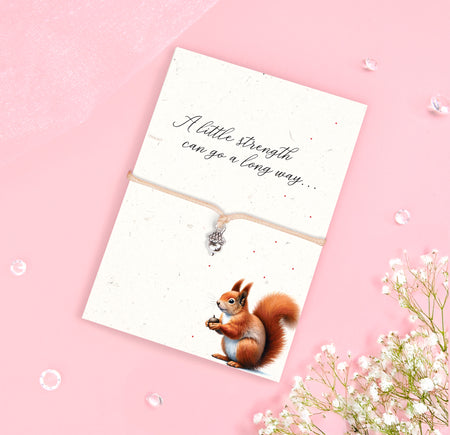Acorn charm bracelet with a beige adjustable cord, presented on an eco-friendly seeded card with wildflower seeds and a message of strength.