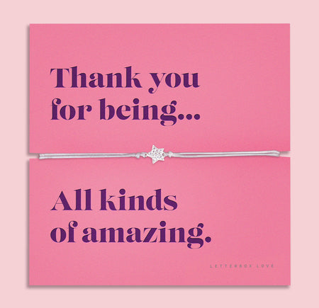 A silver-plated star charm bracelet on a soft, adjustable cord, displayed on a vibrant pink backing card with the message: