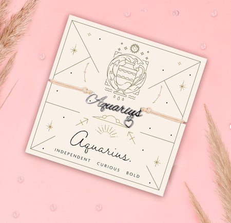 Aquarius-themed bracelet on a matching card with decorative elements on a pink background. Star sign jewellery for women.