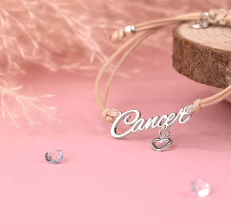Bracelet with 'Cancer' charm on a pink background. Star sign jewellery under £20, zodiac bracelet for a birthday gift