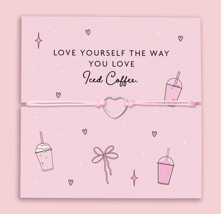 A pastel pink bracelet with a silver-plated heart charm, displayed on a matching pink card with the phrase