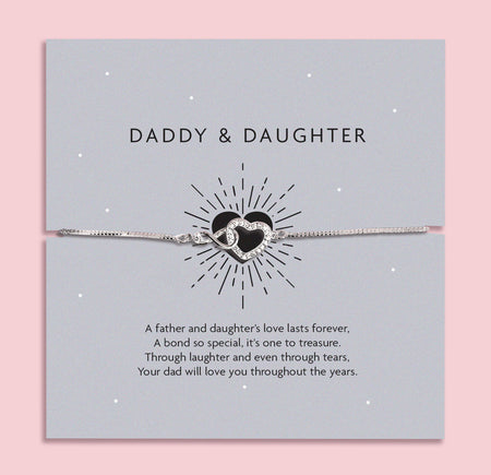 Silver infinity heart bracelet on a grey card with the words