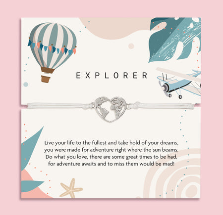 Letterbox Love 'Explorer' travel-themed bracelet – silver heart world map charm on a white cord, displayed on an adventure-inspired card with a hot air balloon, airplane, and uplifting message. Perfect gift for travellers, backpackers, graduates or anyone chasing their dreams. A thoughtful letterbox gift for wanderlust and new journeys.