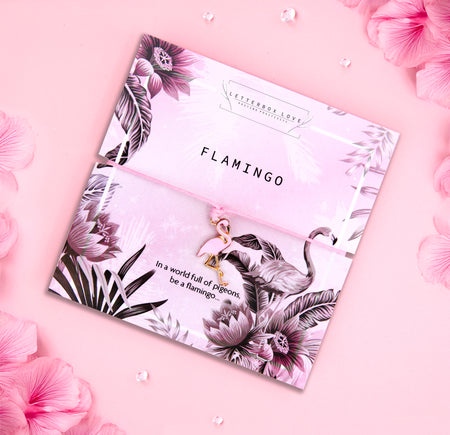 Flamingo charm bracelet with pink cord on a floral and tropical-themed card with the phrase