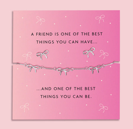 Silver-plated brass bow bracelet and earrings set, featuring delicate bow charms, presented on a pink card with a heartfelt sentiment about friendship.