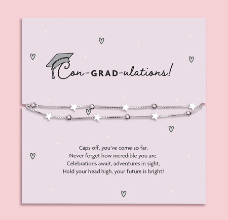 Silver star graduation bracelet on a pale grey card with a mortarboard and poem, titled “Con-GRAD-ulations!” – a perfect gift for her special day.