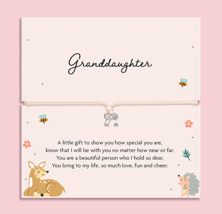 Silver bow charm bracelet on a beige cord, displayed on a pastel card with cute woodland animals and a sentimental message for a granddaughter.