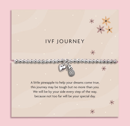 Silver beaded stretch bracelet with heart and pineapple charms on a soft beige sentiment card titled