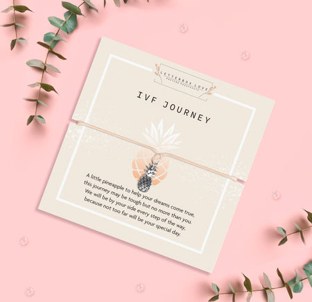 Pineapple charm bracelet for IVF journey, presented with a heartfelt sentiment card offering encouragement and support. The design includes a small silver pineapple charm on a beige cord with a meaningful message.