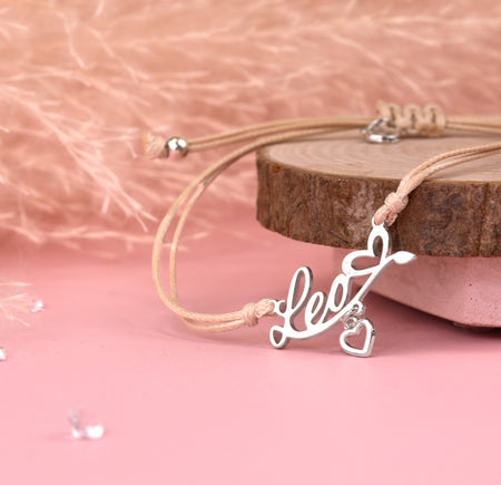 Silver necklace with 'love' pendant on a pink background. Affordable star sign jewellery for women. Leo bracelet under £20
