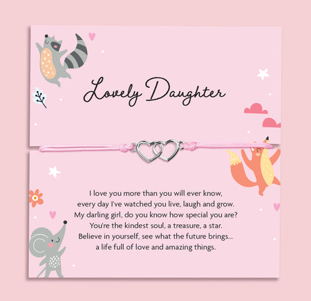 Pink adjustable string bracelet with two silver interlocking heart charms, displayed on a card that reads