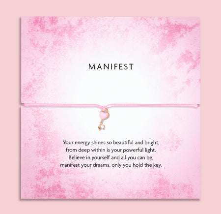 Pink 'Manifest' bracelet with heart key charm on a soft pink poem card with a motivational message. A motivational gift for a friend.