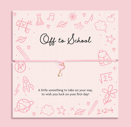 Pink cord bracelet with a rose gold heart key charm, displayed on a school-themed sentiment card reading 'Off to School ' A little something to take on your way, to wish you luck on your first day!” from Letterbox Love.