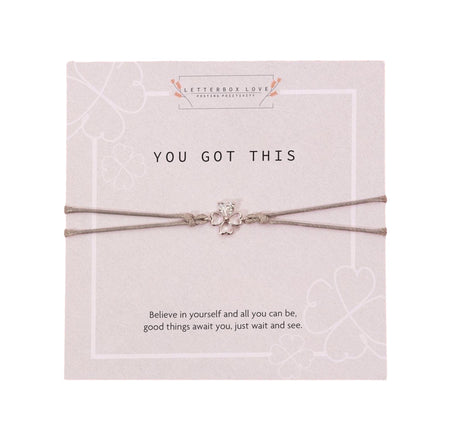 Encouragement-themed gift card from Letterbox Love with the phrase 'YOU GOT THIS' in bold lettering at the top. The card includes a short, uplifting message 'Believe in yourself and all you can be, good things await you, just wait and see.' In the center is a dainty silver-colored clover charm attached to a gray adjustable bracelet, symbolizing luck and positivity. The background of the card features subtle outlines of four-leaf clovers, adding to the theme of good fortune and self-belief.