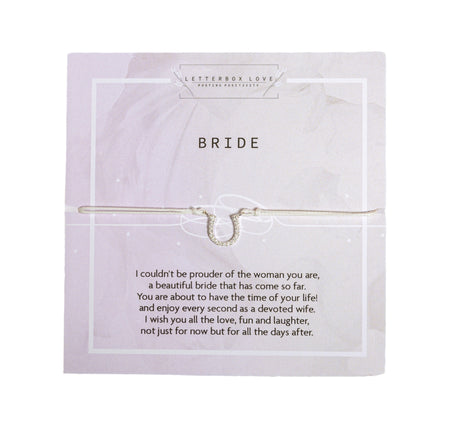 Wedding-themed gift card from Letterbox Love titled 'BRIDE' at the top in elegant font. The card has a heartfelt message that reads 'I couldn't be prouder of the woman you are, a beautiful bride that has come so far. You are about to have the time of your life! and enjoy every second as a devoted wife. I wish you all the love, fun and laughter, not just for now but for all the days after.' A delicate, silver-colored horseshoe charm representing good luck is attached to a white adjustable bracelet.
