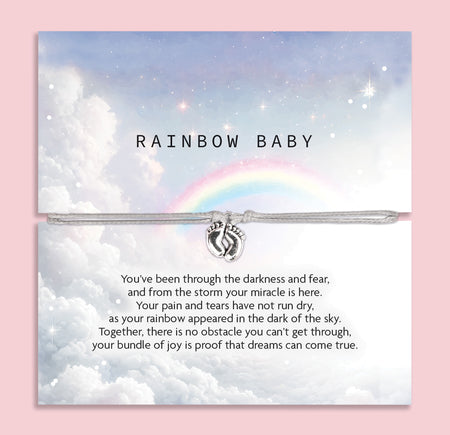 An image of a sentimental card featuring a silver bracelet with a small charm of intertwined hands. The card has a soft, dreamy design with a cloudy sky and a rainbow in the background. The text on the card reads