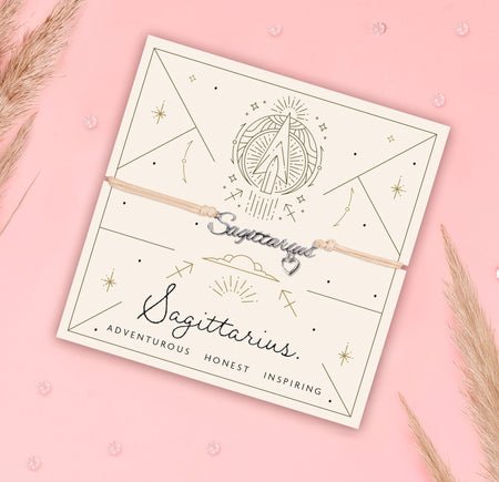 Sagittarius-themed bracelet on a branded card with decorative elements on a pink background. Star sign jewellery for women under £20