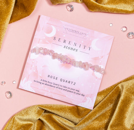 Elegant 'SERENITY stones' card from Letterbox Love featuring a strand of polished rose quartz beads. The card is labeled 'ROSE QUARTZ' with a description that reads 'A little rose quartz to take on your way, to bring an abundance of love and peace to your day.'