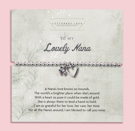 A silver beaded bracelet with a heart and flower charm displayed on a card reading