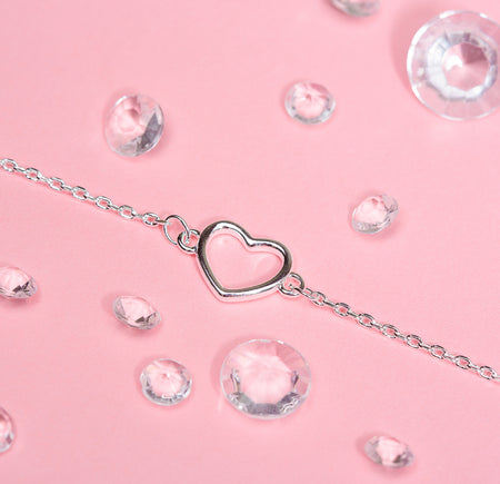 Pretty silver detail bracelet on a pink background surrounded by gems. The bracelet is dainty making an elegant leaving gift for a colleague