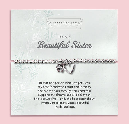 Silver beaded bracelet with heart and flower charms, displayed in a white gift box alongside a card titled