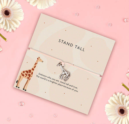 A silver giraffe charm on a beige adjustable cord, accompanied by a sentiment card reading,