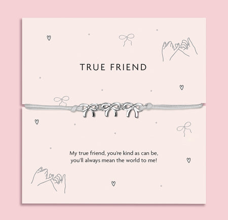 Silver Bows charm bracelet on a pastel pink card with the message