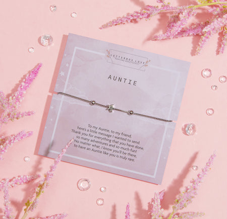 A heartwarming greeting card dedicated to 'Auntie'. The card features a thoughtful message expressing gratitude and admiration. Above the written sentiment is a delicate silver bracelet with a star charm, elegantly placed on the card.