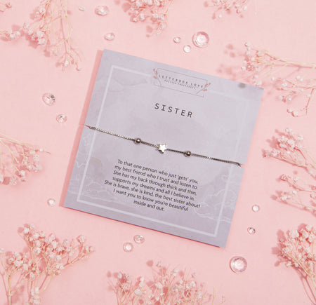 Elegant card titled 'SISTER' with a heartfelt message celebrating the bond of sisterhood, accompanied by a dainty bracelet with a star charm.