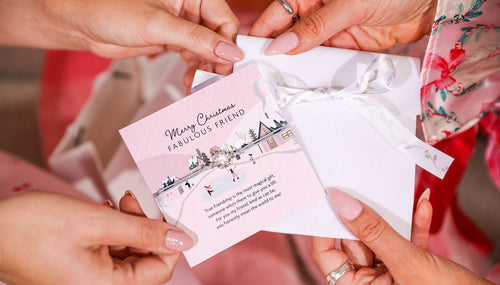 Two women gifting a Fabulous Friend wreath bracelet with a white velvet pouch