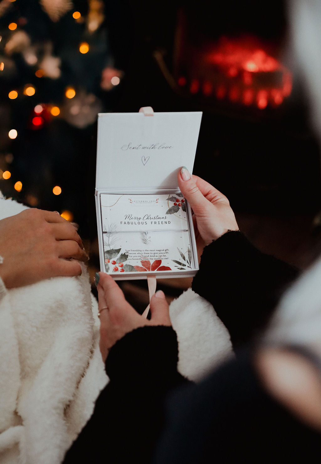 A woman holding a Christmas Friendship Present in a letterbox love gift box