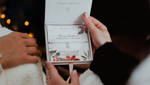 A woman holding a Christmas Friendship Present in a letterbox love gift box