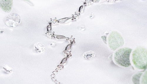 silver plated bracelet on a white background with gems and eucalyptus stems