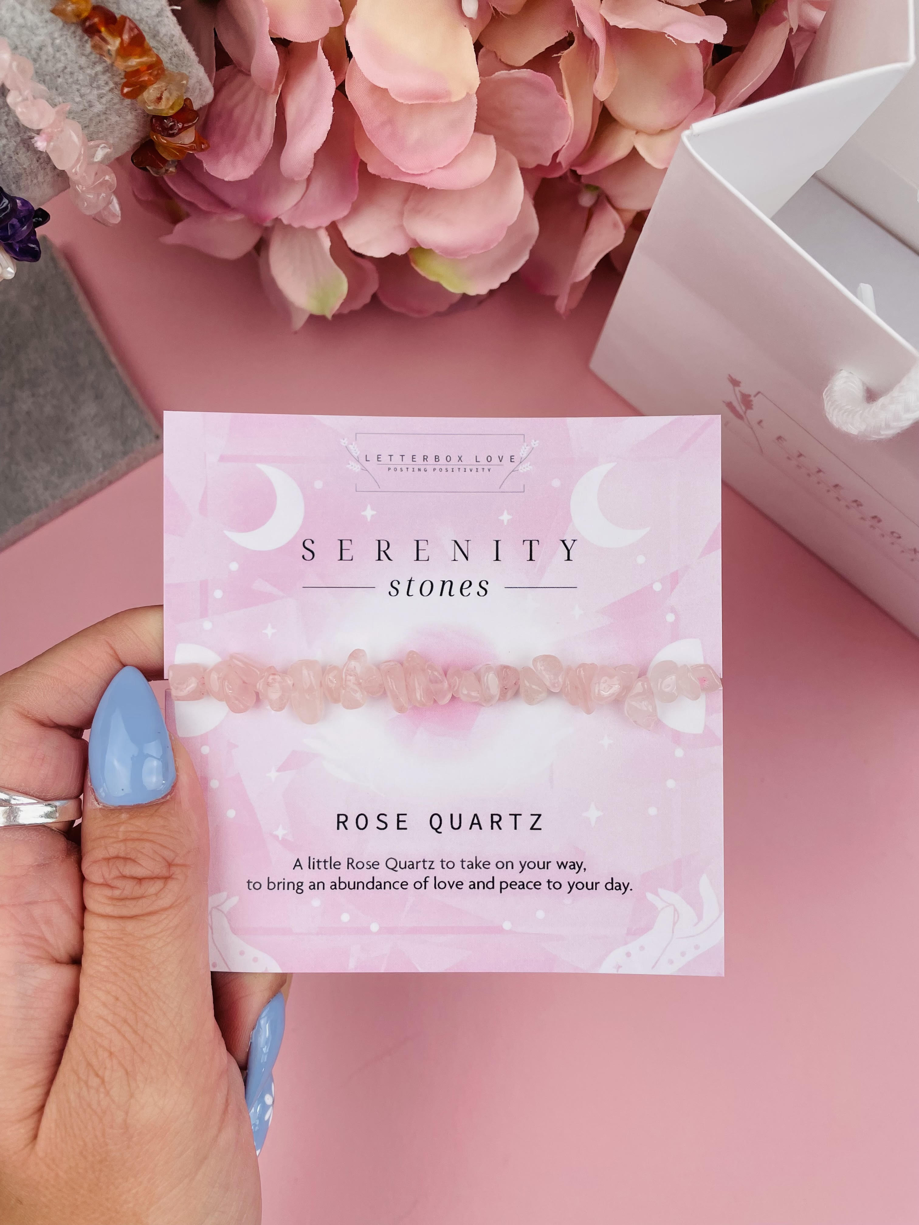 pink crystal bracelet on a pink card being held by a woman with blue nails