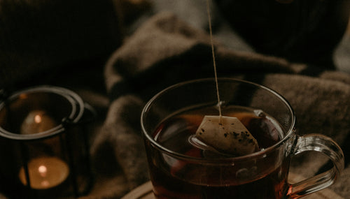 a cosy autumn scene with a woman hand making a cup of tea