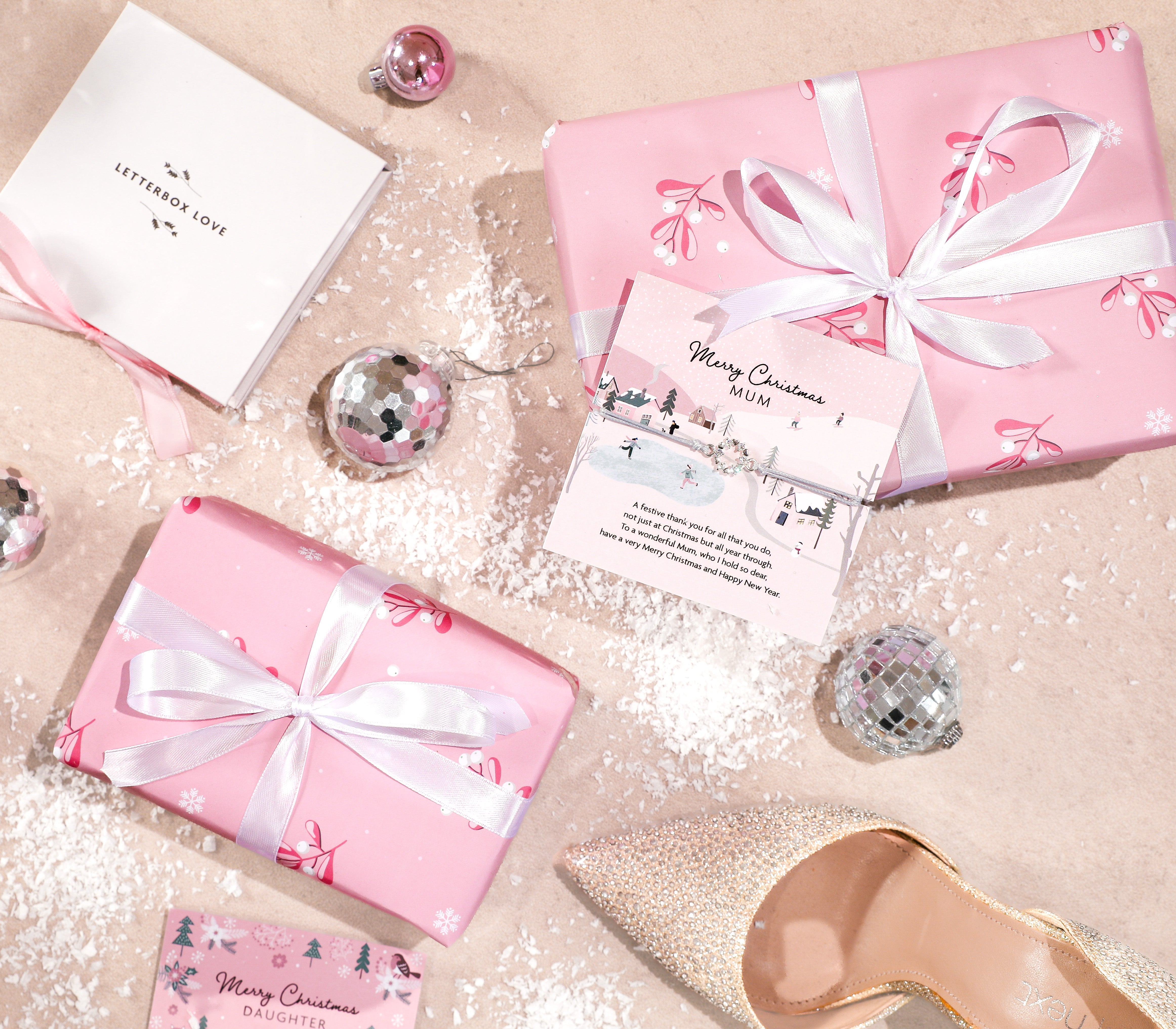 a flat lay with pink parcels and a meaningful mum bracelet. A beautiful gift from daughter to mum
