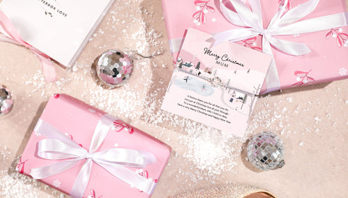 a flat lay with pink parcels and a meaningful mum bracelet. A beautiful gift from daughter to mum