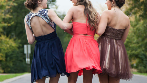three girls on the way to prom in colourful dresses