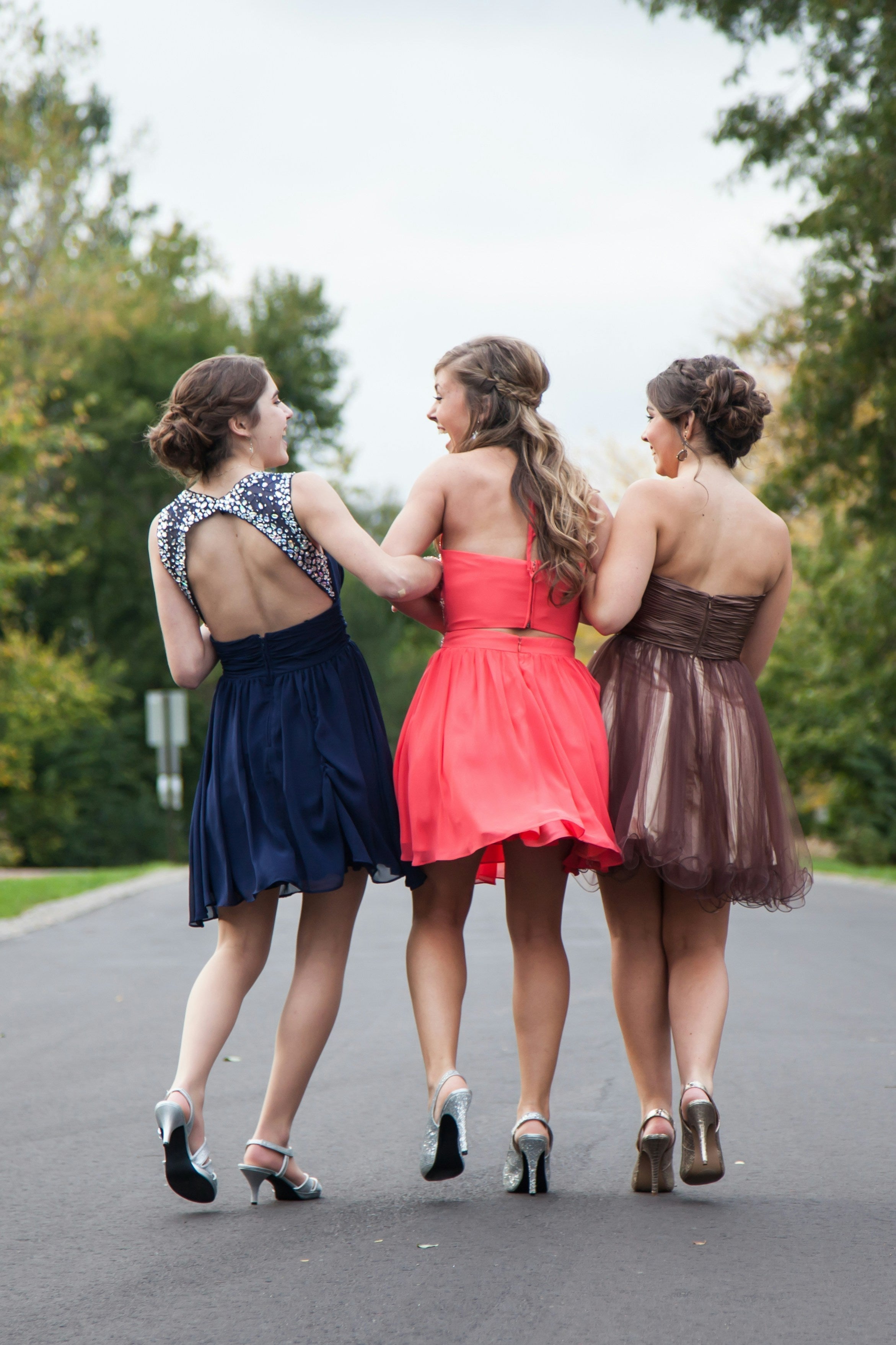 three girls on the way to prom in colourful dresses