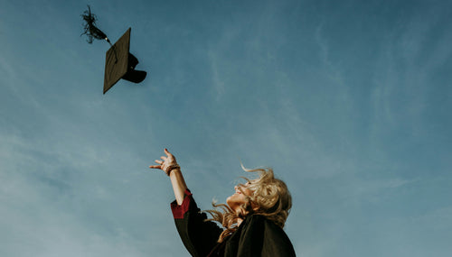 a girl graduating and throwing her mortarboard into the air