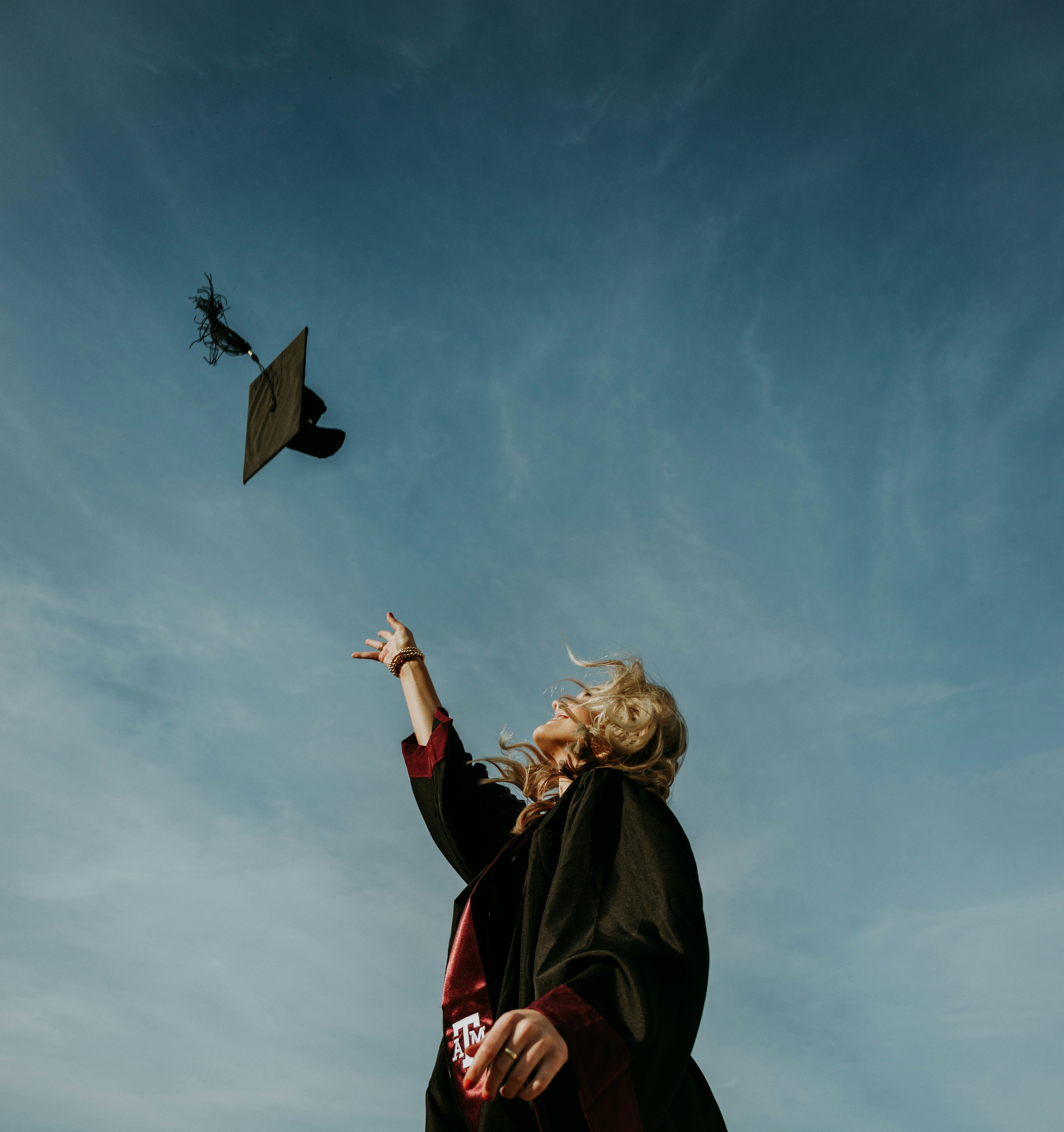 a girl graduating and throwing her mortarboard into the air
