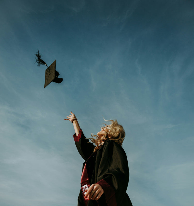 a girl graduating and throwing her mortarboard into the air