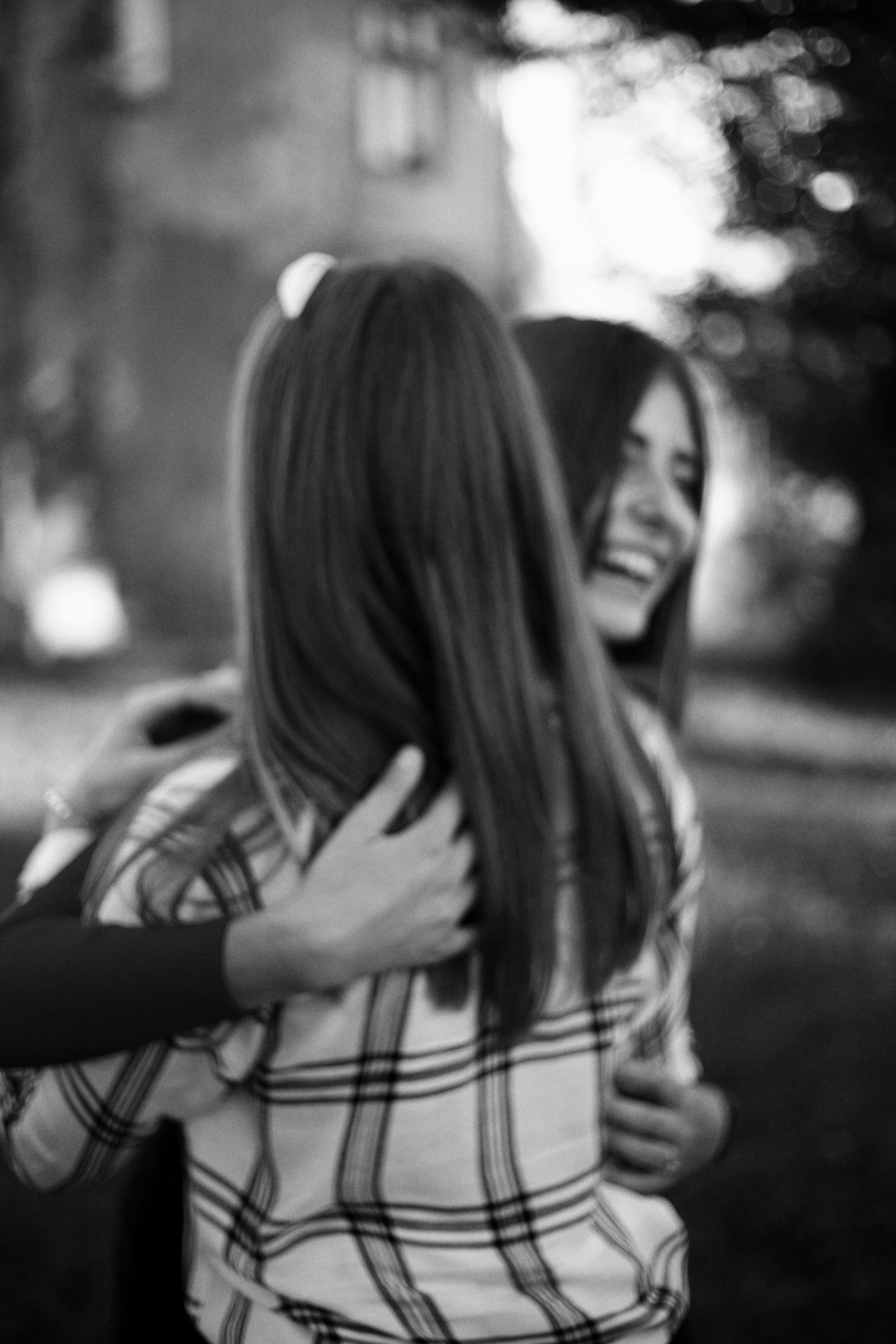 A black and white image of two women hugging farewell