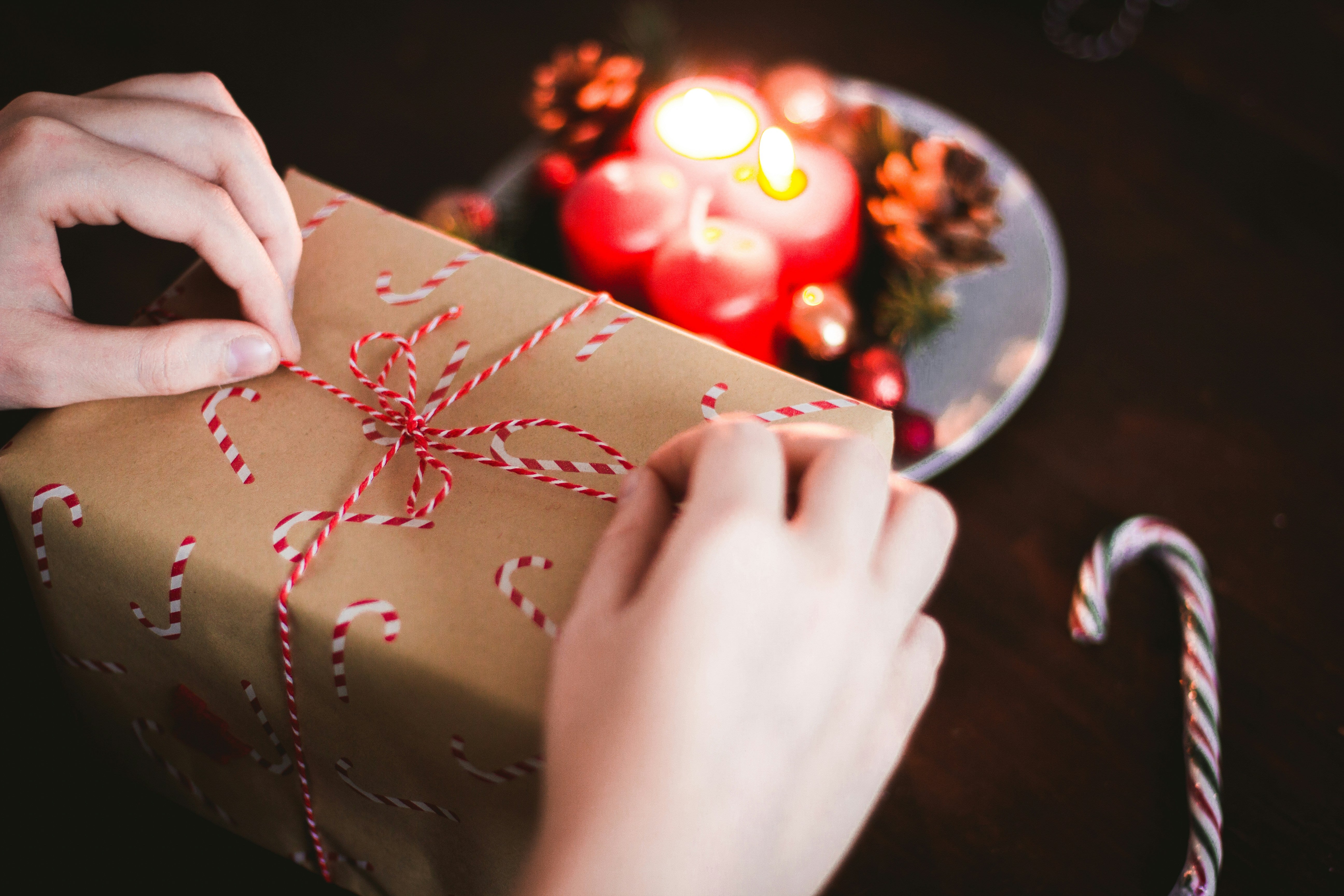 women's hands tying a string bow on a Christmas present