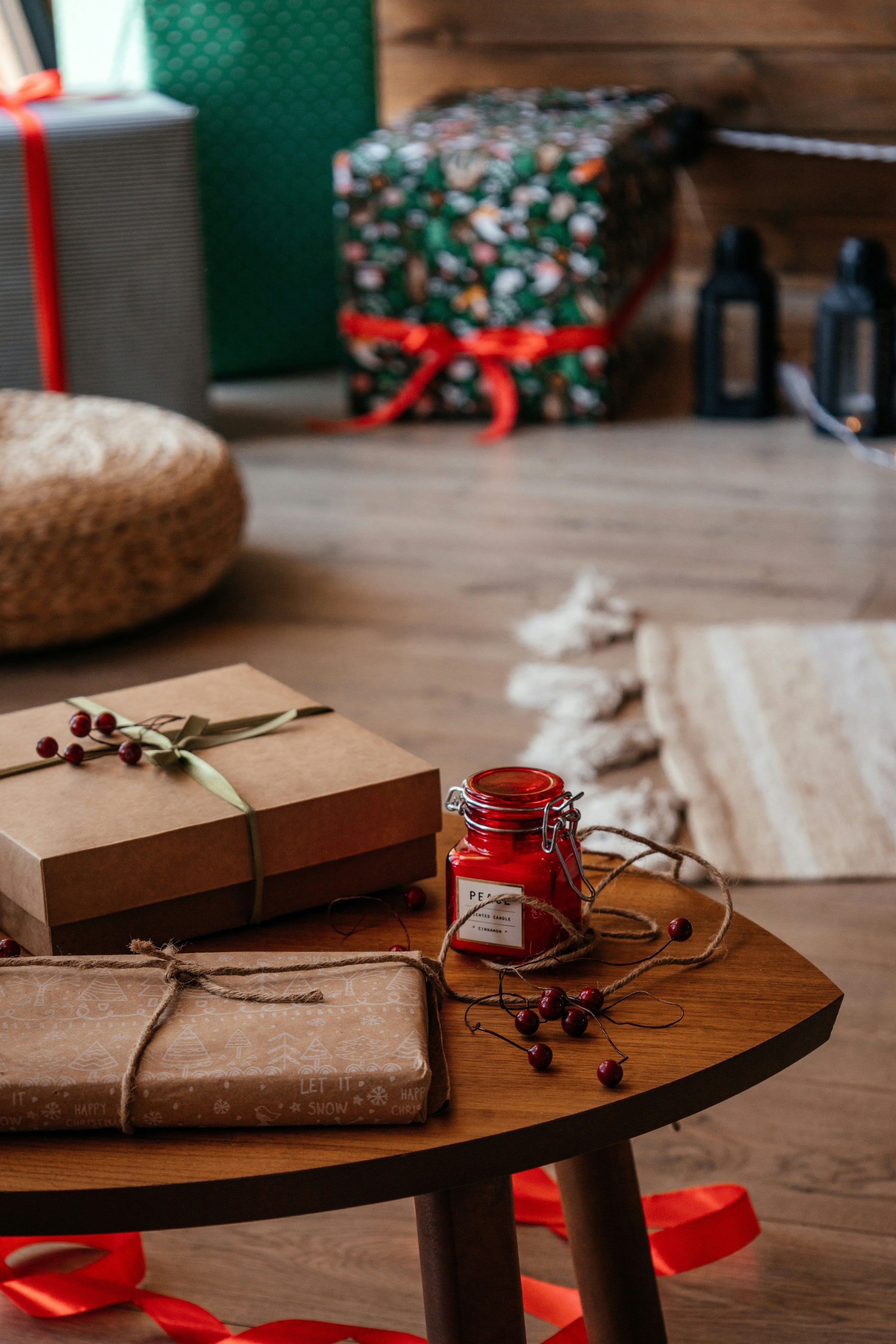 a wooden floor with wooden coffee table and gifts wrapped in brown paper and a red candle