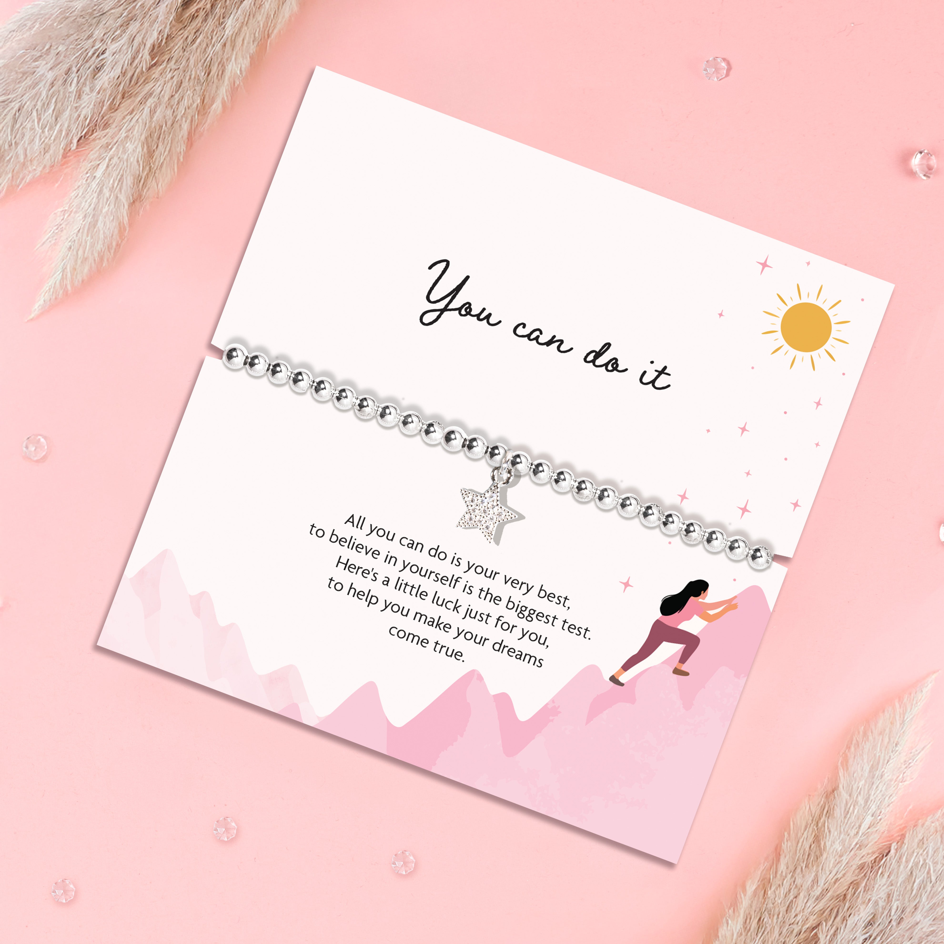 A pink background with a 'You Can do it' poem card. The silver-plated bracelet is a lucky charm with a sparkly star charm.