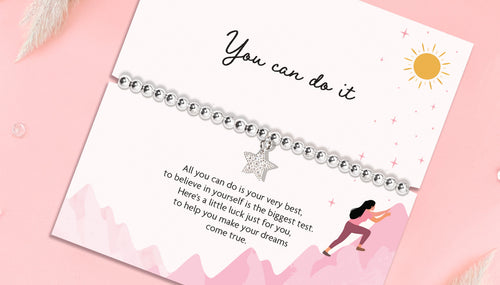 A pink background with a 'You Can do it' poem card. The silver-plated bracelet is a lucky charm with a sparkly star charm.