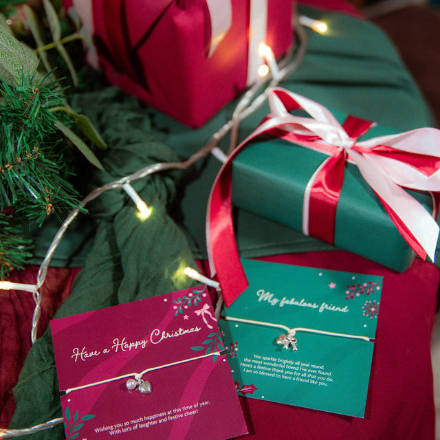 two beautiful christmas bracelets gifts for women on a festive table et up with large wrapped presents.